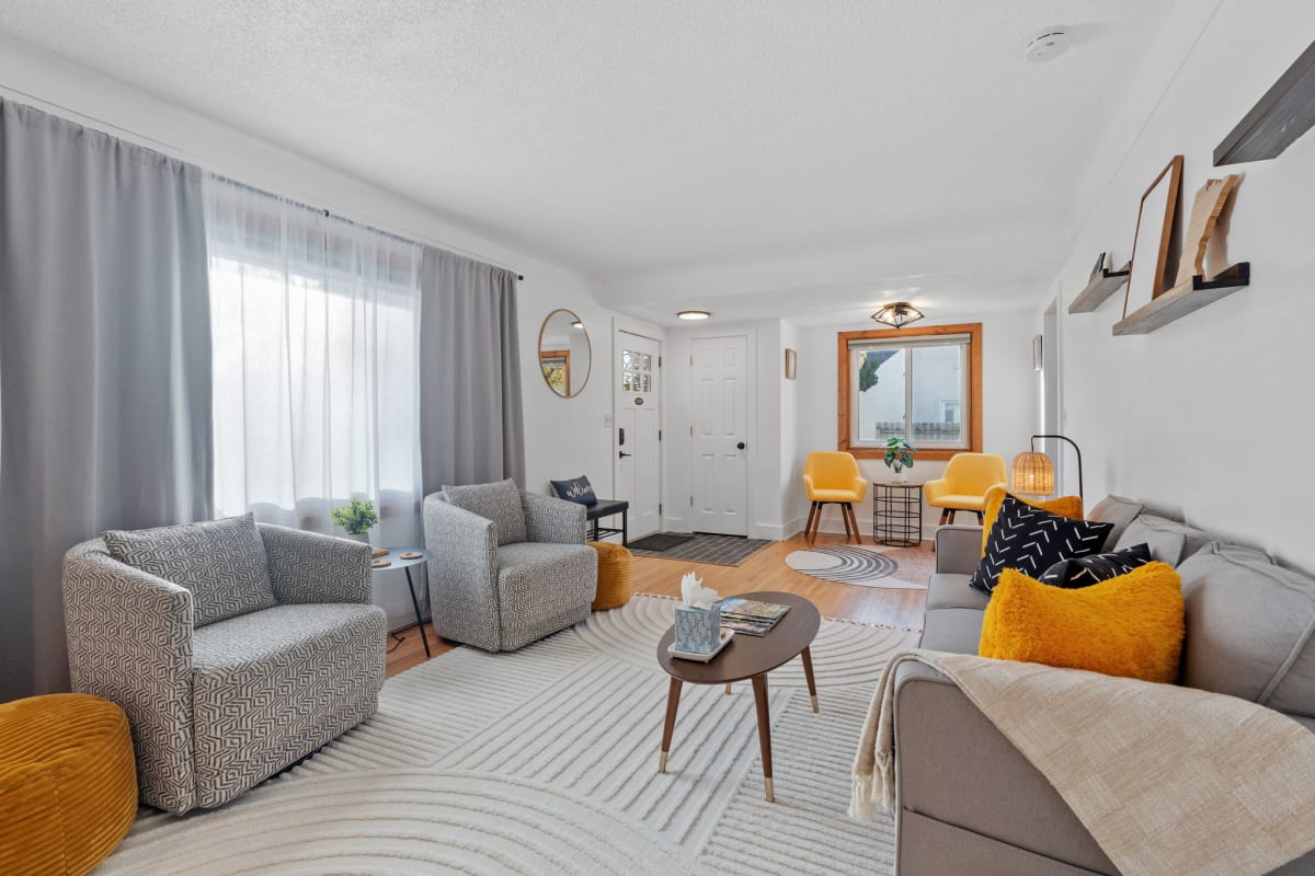 A modern and cozy living room with stylish furniture and cheerful color accents.