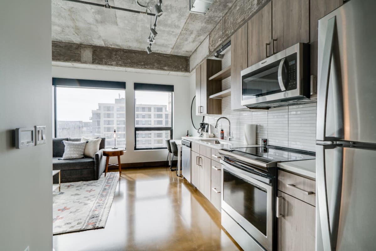 A modern kitchen and living area featuring sleek design and natural light.
