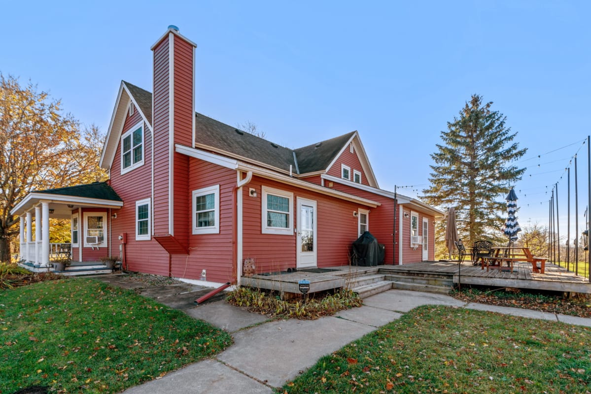 A charming red house with a welcoming porch and a cozy outdoor deck.