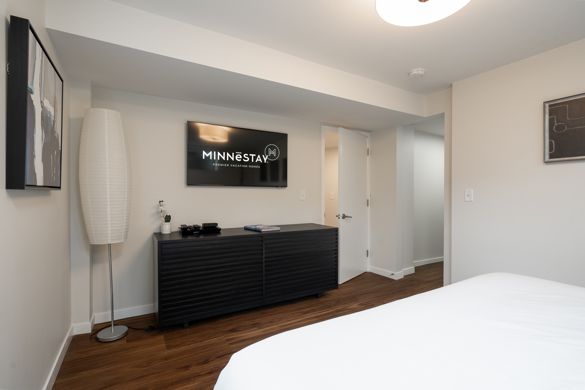 Modern bedroom with minimalist design and vacation rental branding.