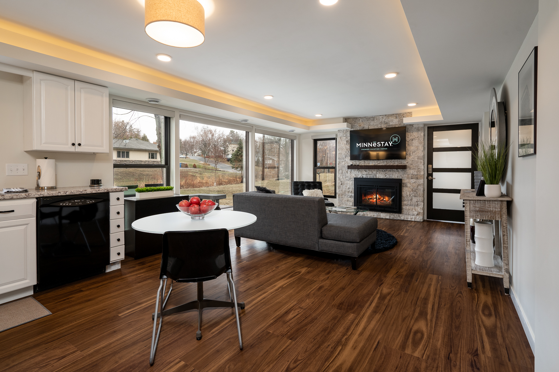 A contemporary living area blending style and comfort, featuring large windows and a cozy fireplace.