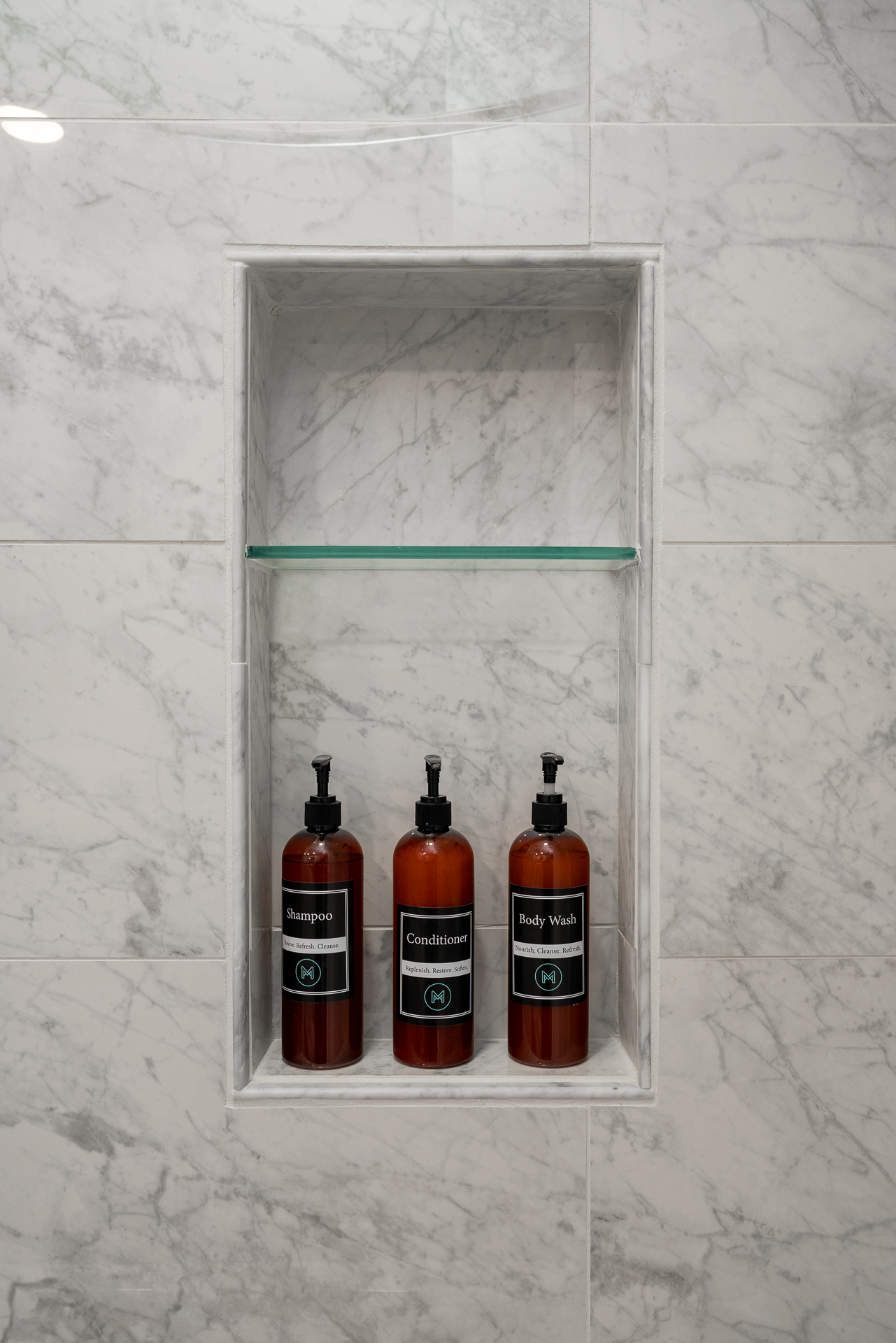 Stylish shower niche with shampoo, conditioner, and body wash.