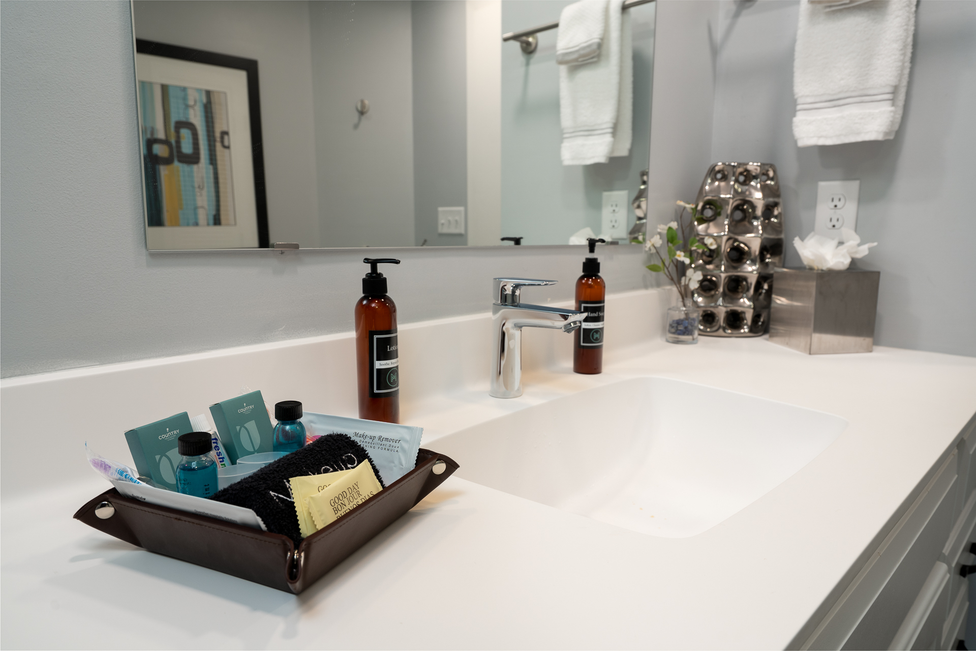 A modern bathroom sink area with neatly arranged toiletries and a sleek design.