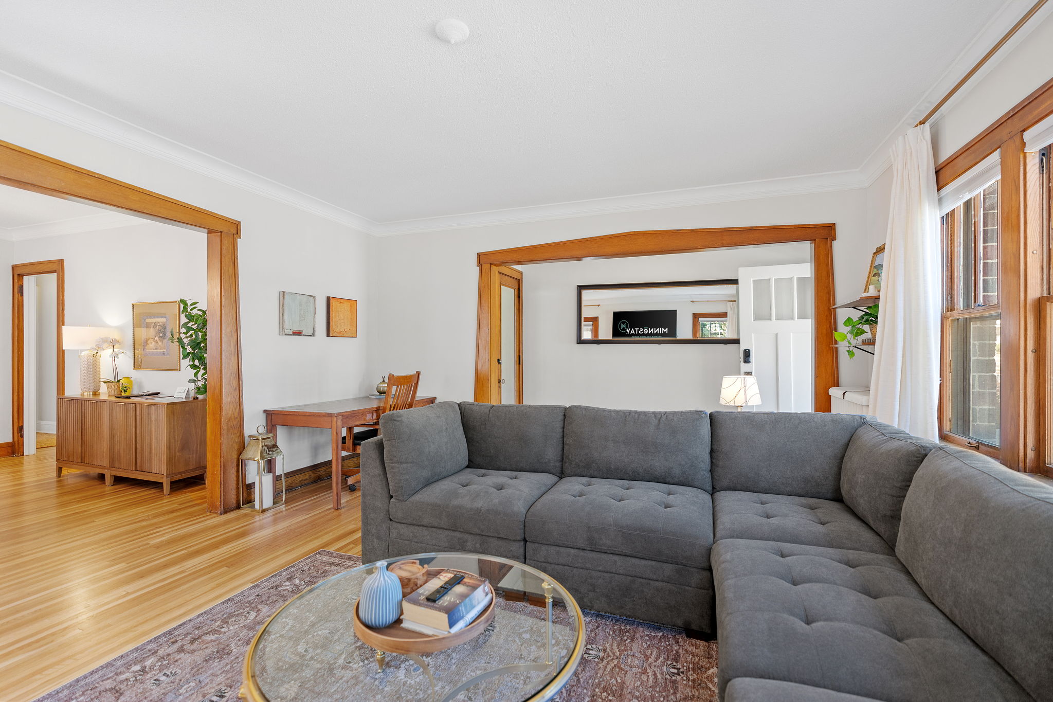 A cozy living room with a gray sectional sofa and wooden accents.
