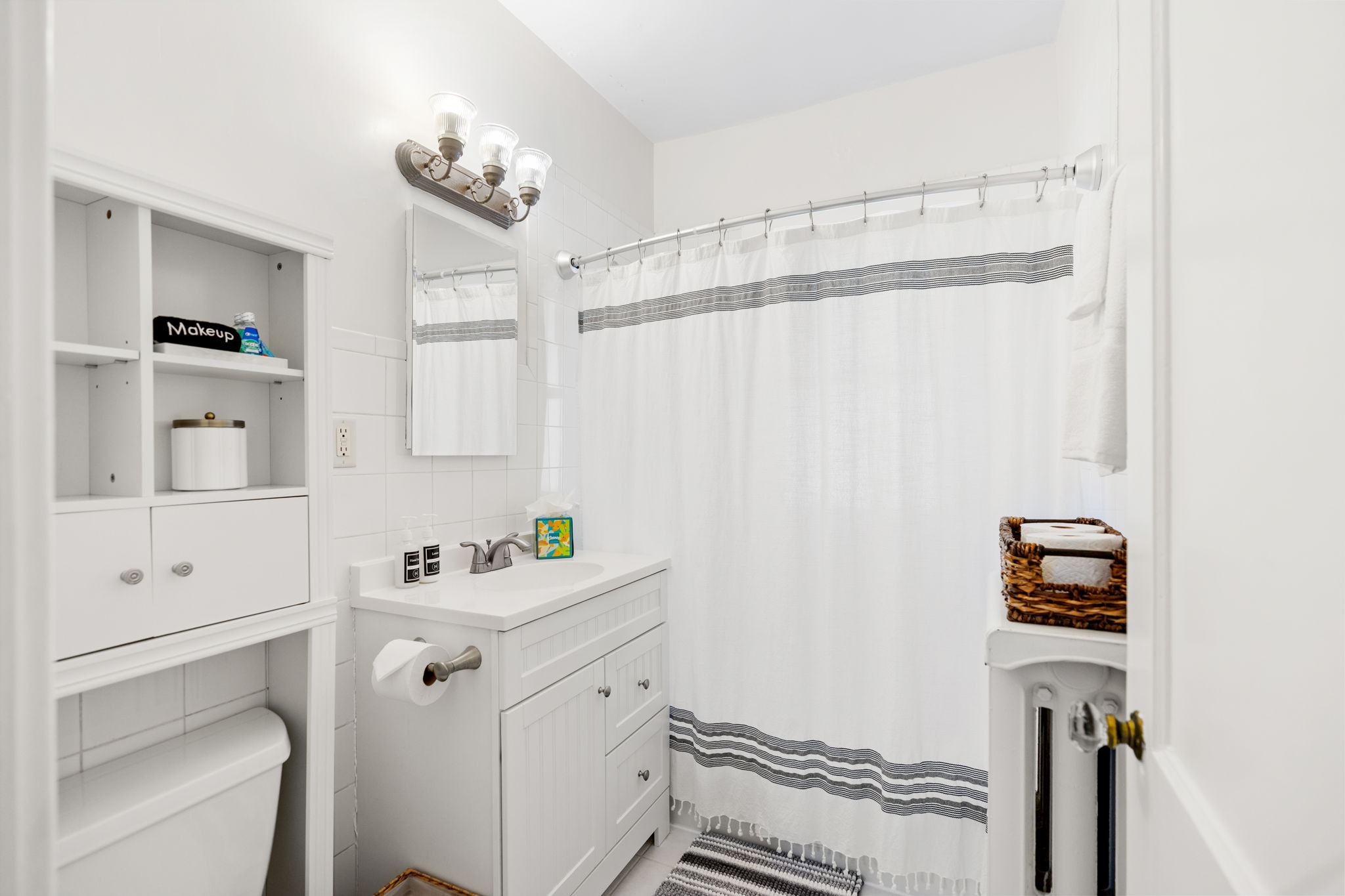 A modern and organized bathroom featuring a white aesthetic and functional storage.