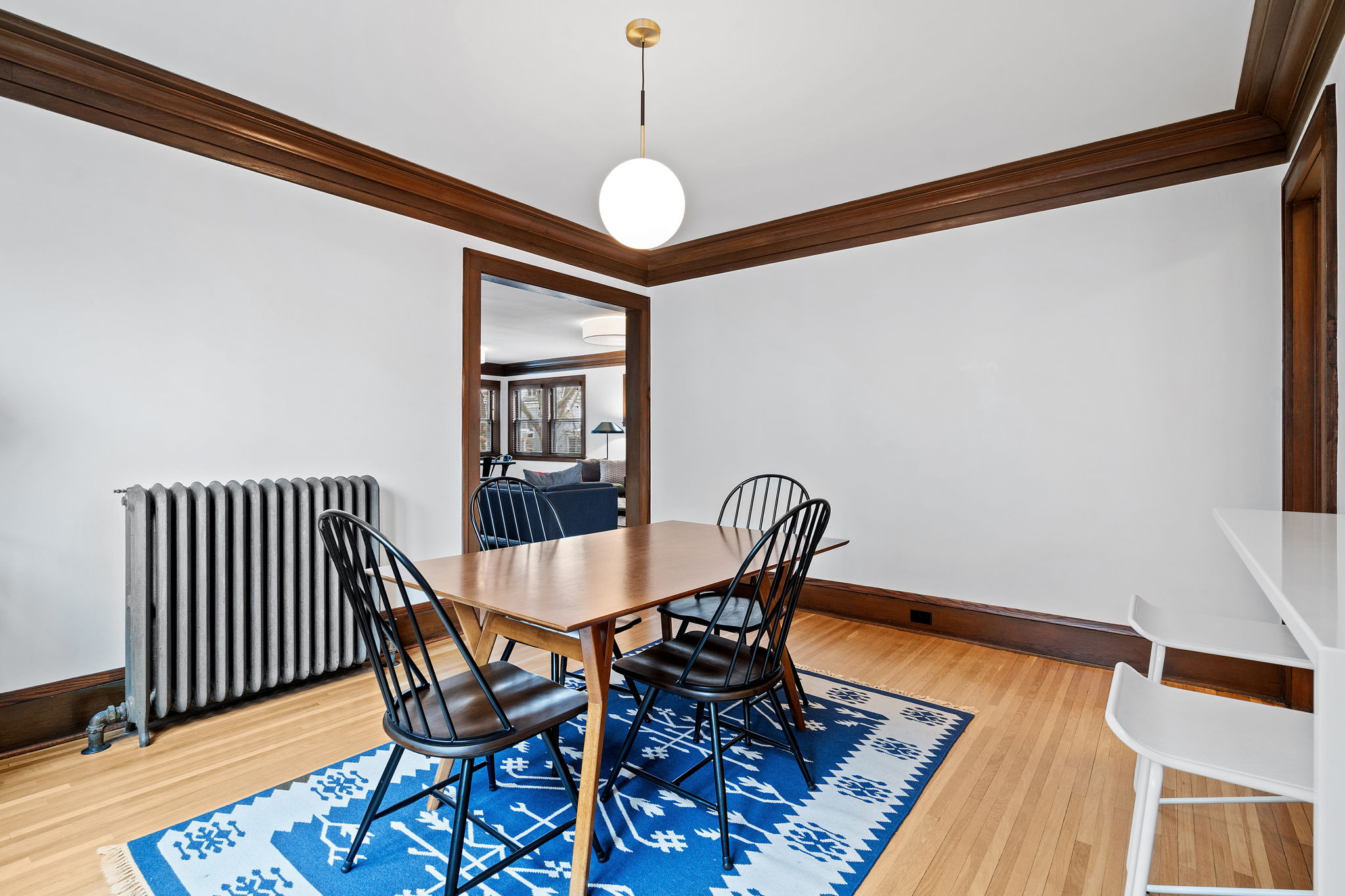 Bright dining area with a wooden table and black spindle-back chairs.