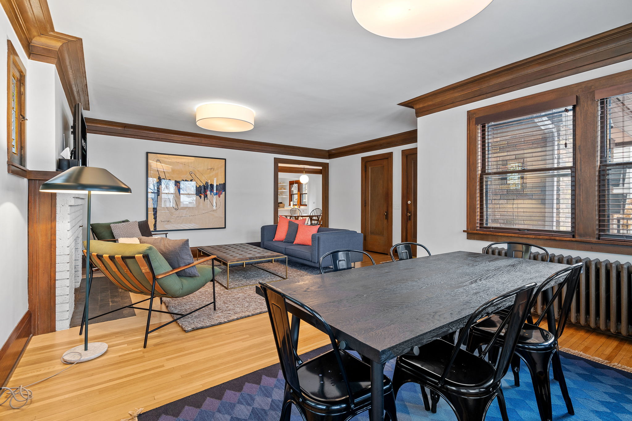 A modern living and dining area with stylish furniture and artwork.