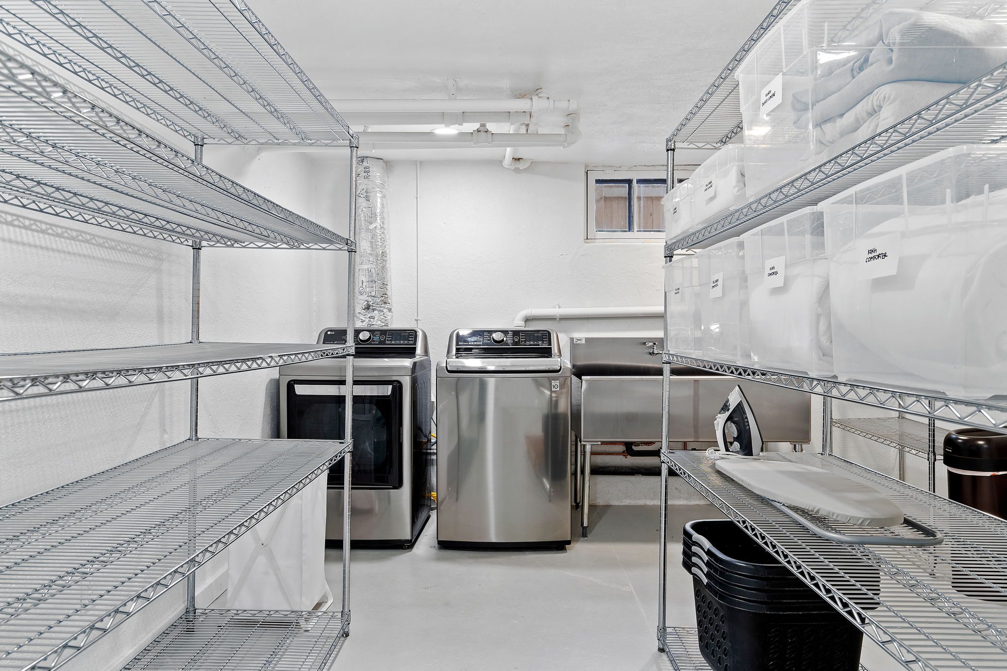 An organized laundry room featuring modern appliances and ample storage.
