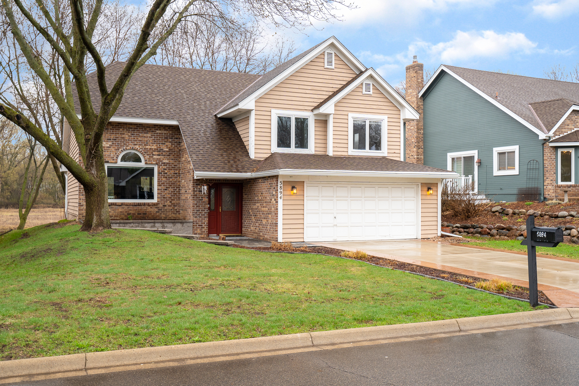 A picturesque suburban home with a blend of brick and siding.