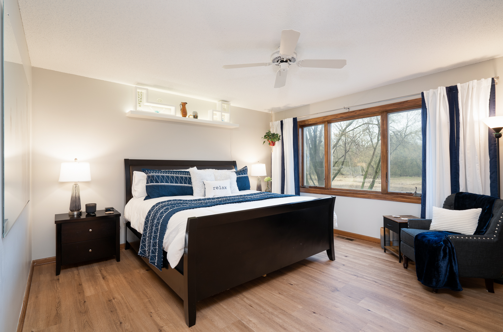 A cozy and inviting bedroom featuring a dark wood bed, soothing color palette, and natural light.