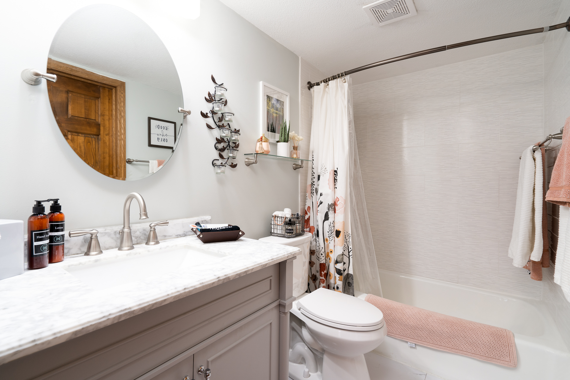 A stylish and serene bathroom featuring marble details and floral decor.