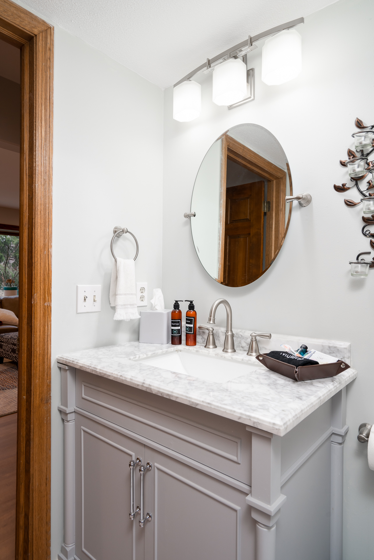 A stylish modern bathroom featuring a gray vanity and marble countertop.