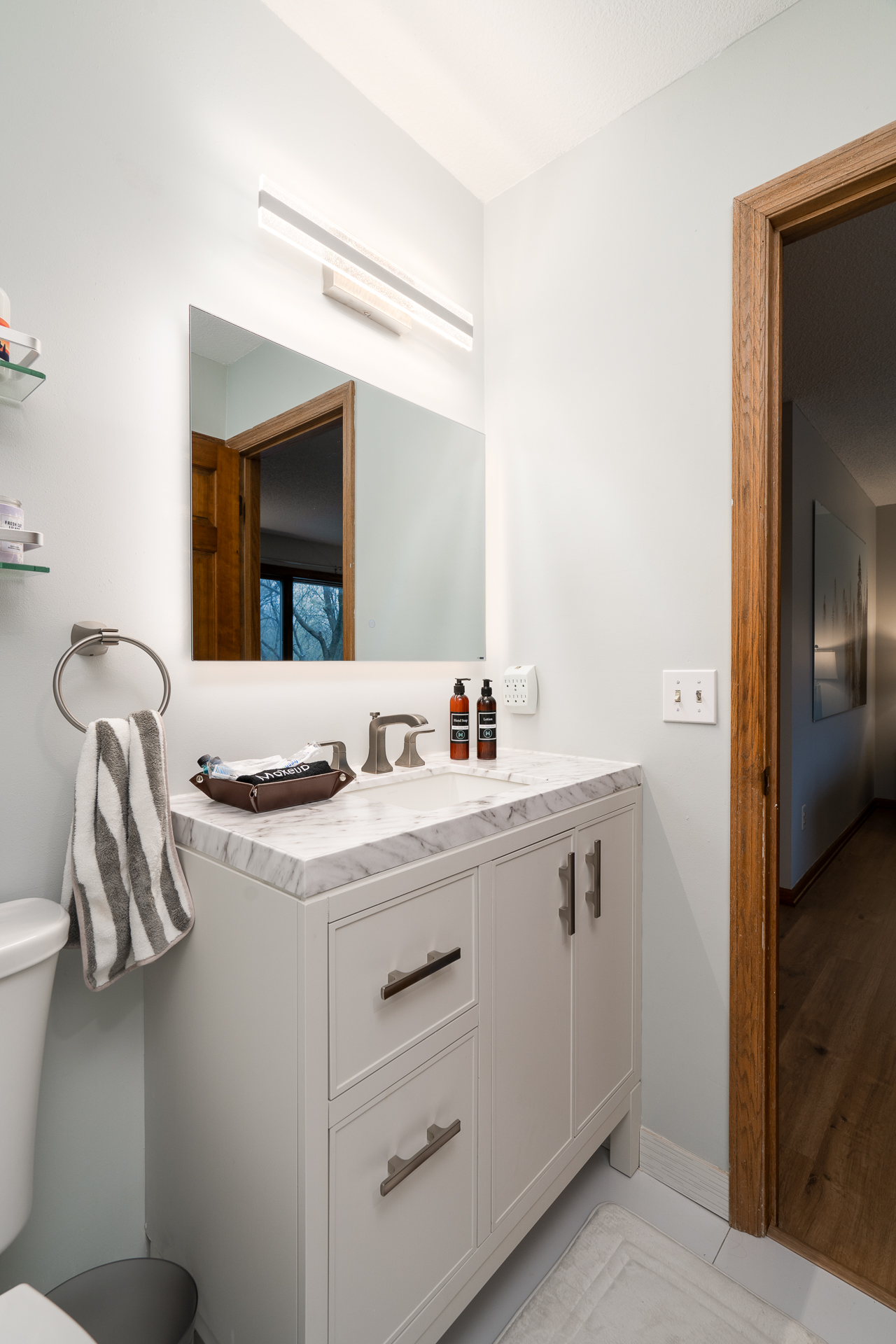 A modern, minimalist bathroom with a stylish vanity and bright lighting.