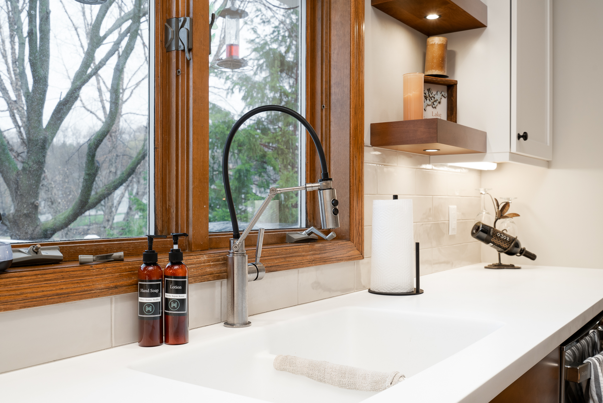 A modern kitchen sink area featuring stylish hand soaps and a sleek faucet.