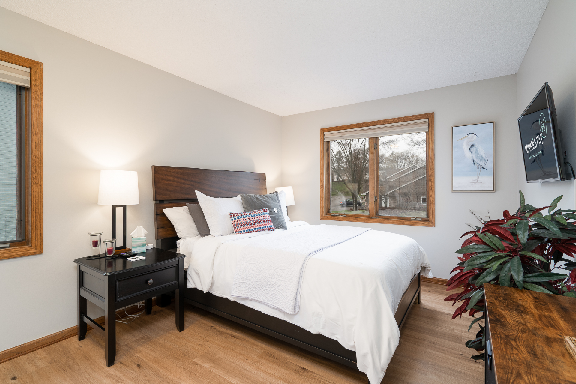A cozy and stylish bedroom featuring a comfortable bed and a view of nature.