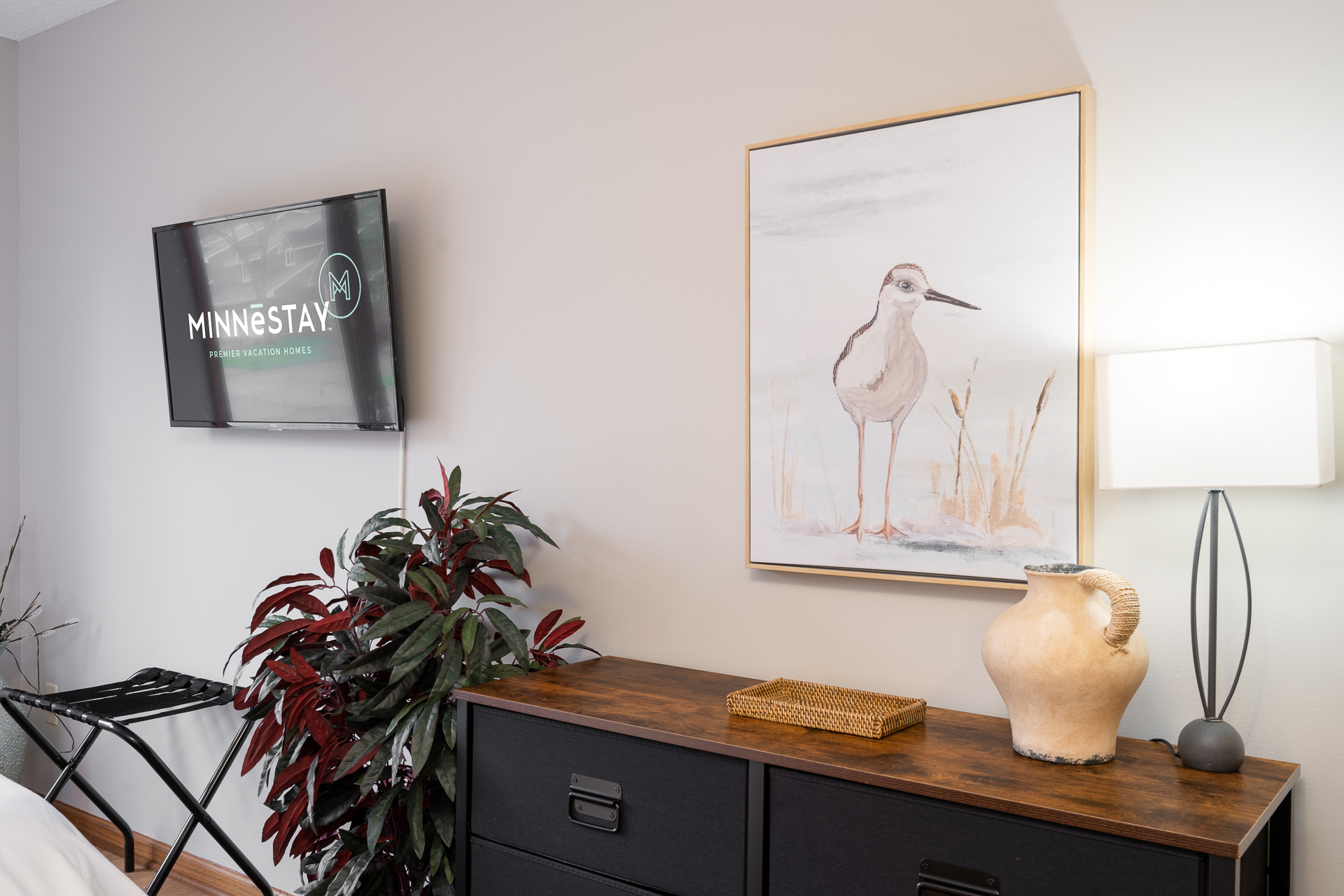 A stylish interior featuring a television, bird art, and decorative elements.