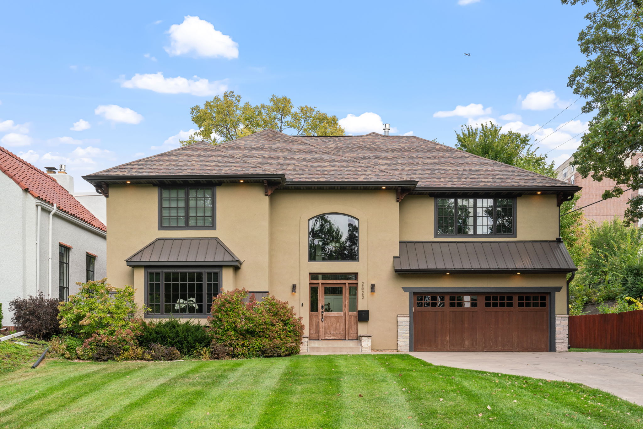 Modern suburban house with inviting entry and landscaped garden.