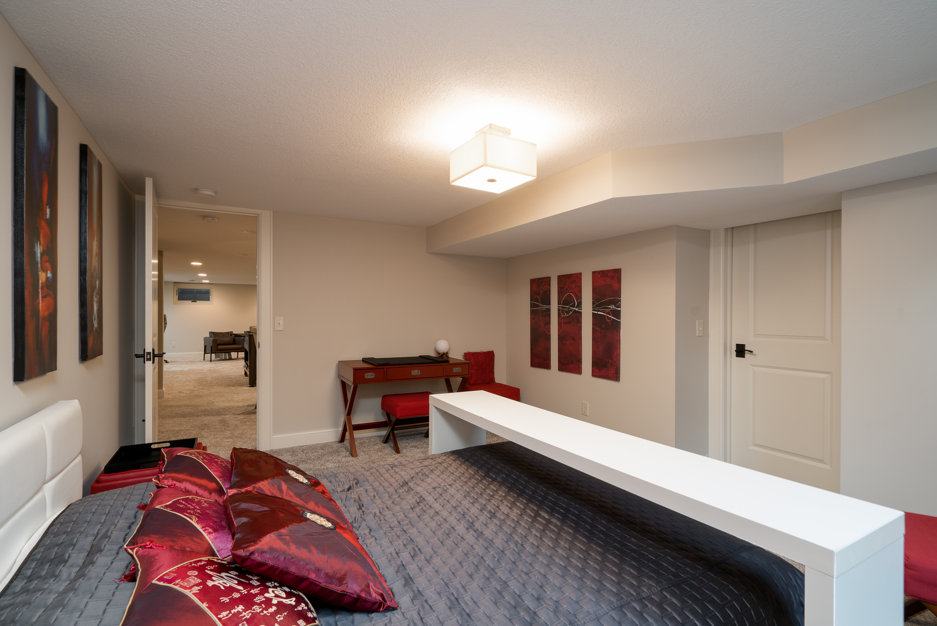 A modern bedroom featuring a cozy design with red and gray accents.
