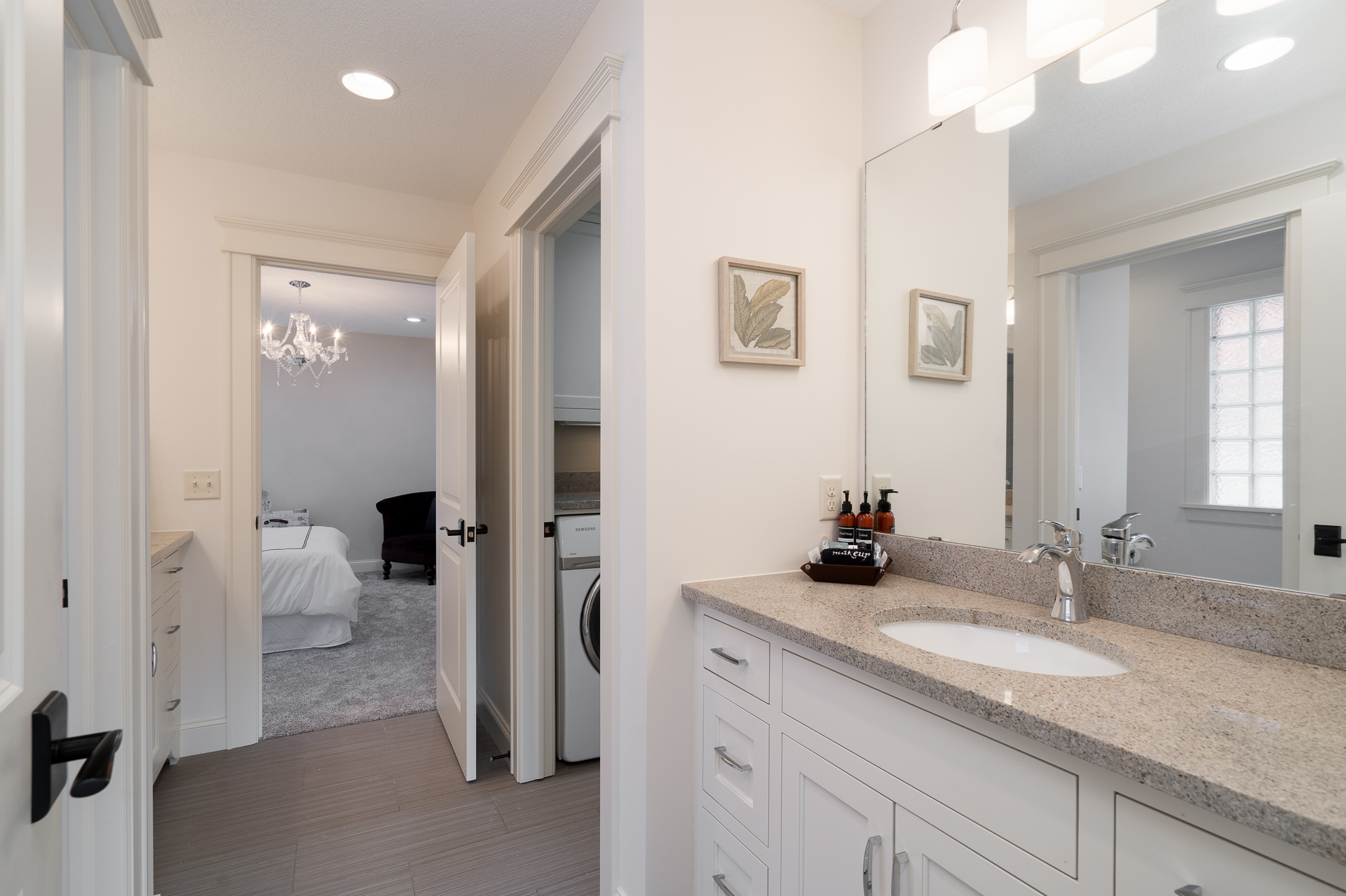 A sleek and modern bathroom featuring elegant details and a glimpse of the adjacent bedroom.