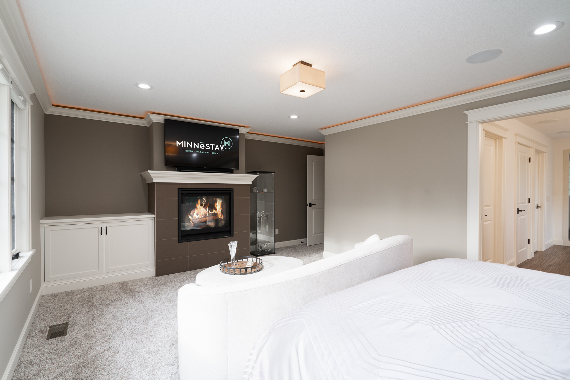 A modern, cozy bedroom with stylish furnishings and a fireplace.