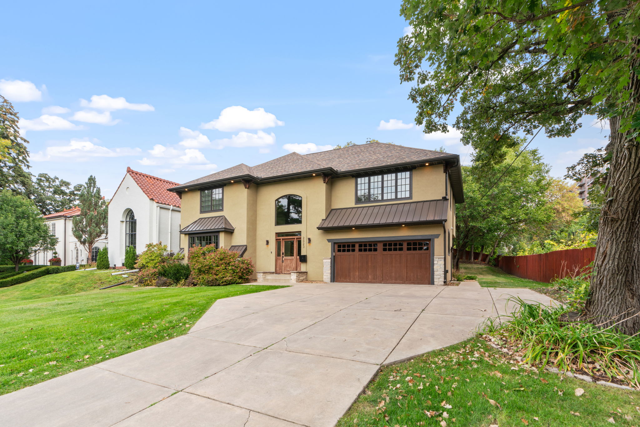 A contemporary two-story home with a well-maintained lawn and distinctive architectural features.