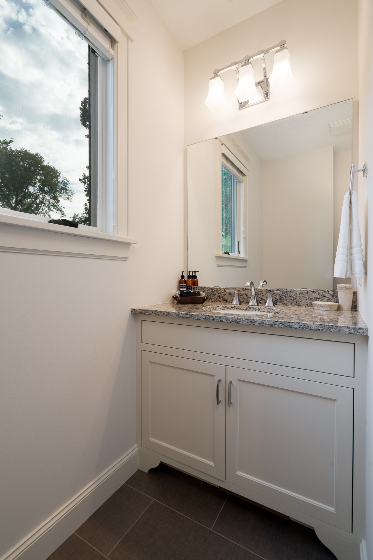 A modern bathroom featuring a granite countertop and elegant fixtures.
