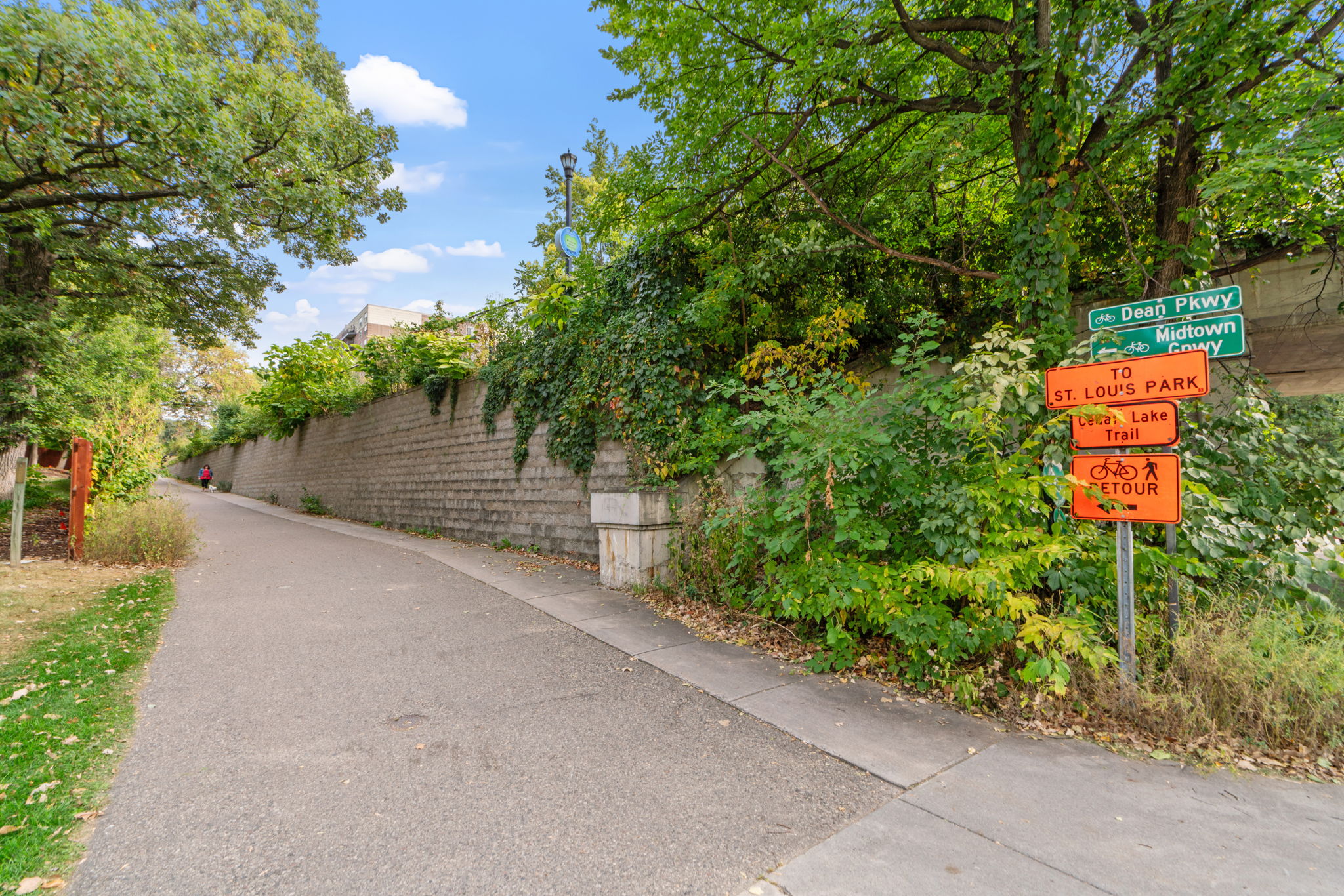 A serene urban trail with signs directing to local parks and trails.