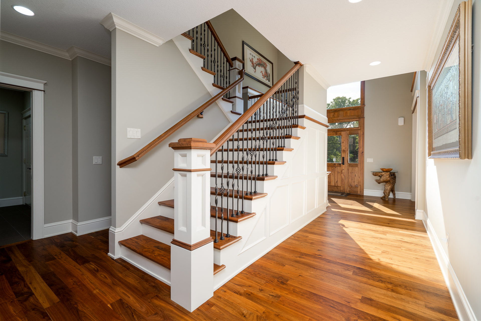 Elegant entrance hall with a wooden staircase and natural light.