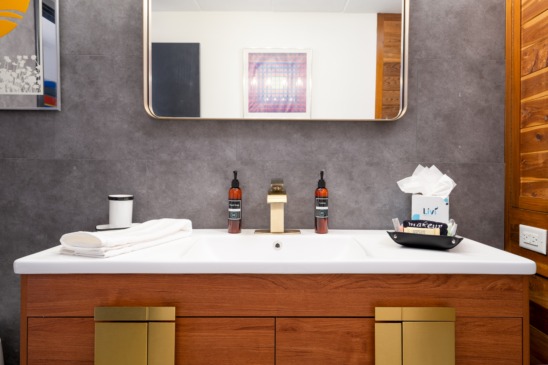 A stylish and modern bathroom vanity featuring a wooden design with gold accents and contemporary fixtures.