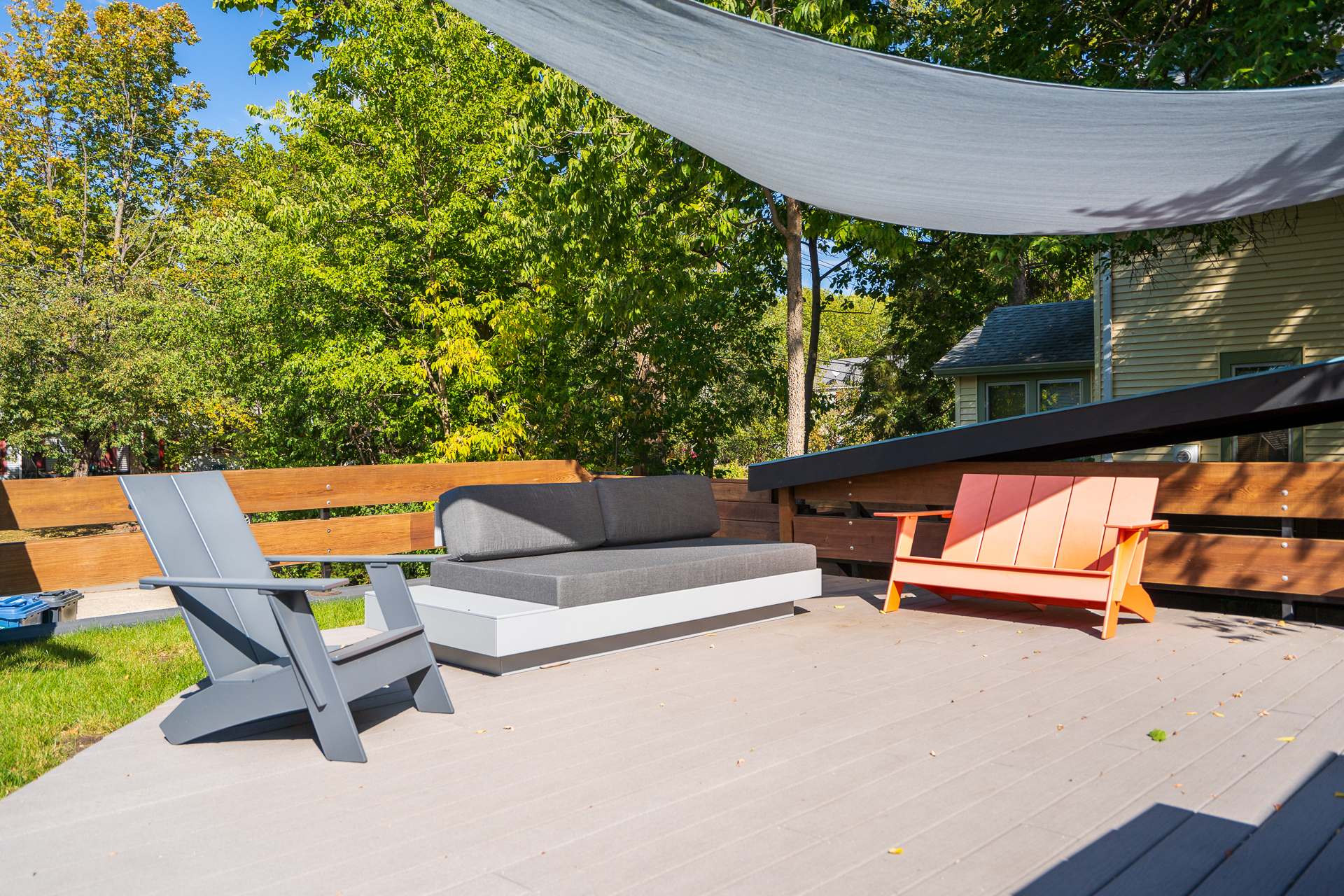 A modern outdoor seating area featuring stylish furniture and a fabric canopy.