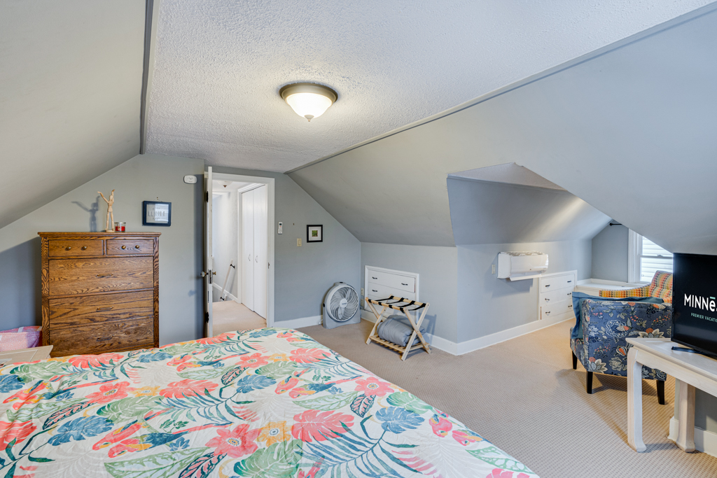 A bright and cozy attic bedroom with floral decor and vintage furnishings.