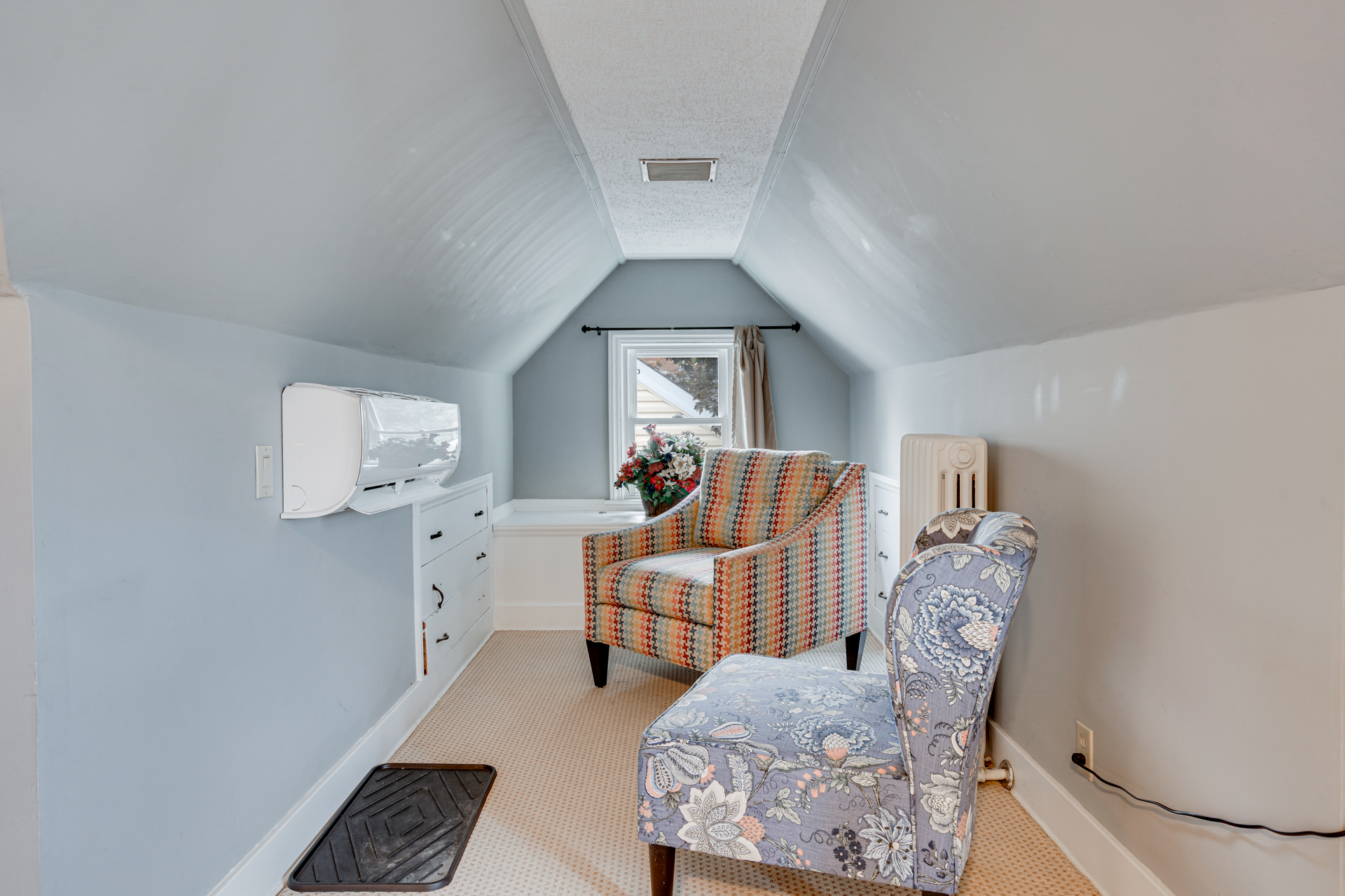 A cozy attic space with colorful chairs and natural light.