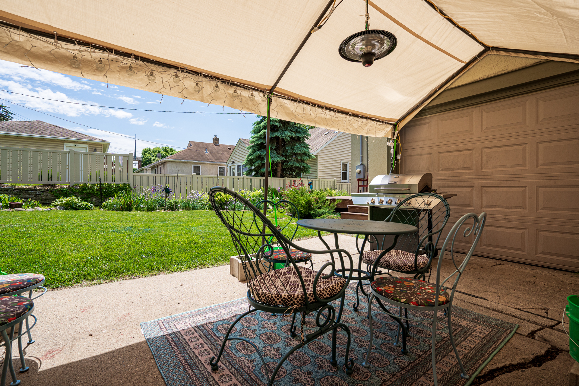 A cozy outdoor patio area featuring a table and chairs under a canopy.