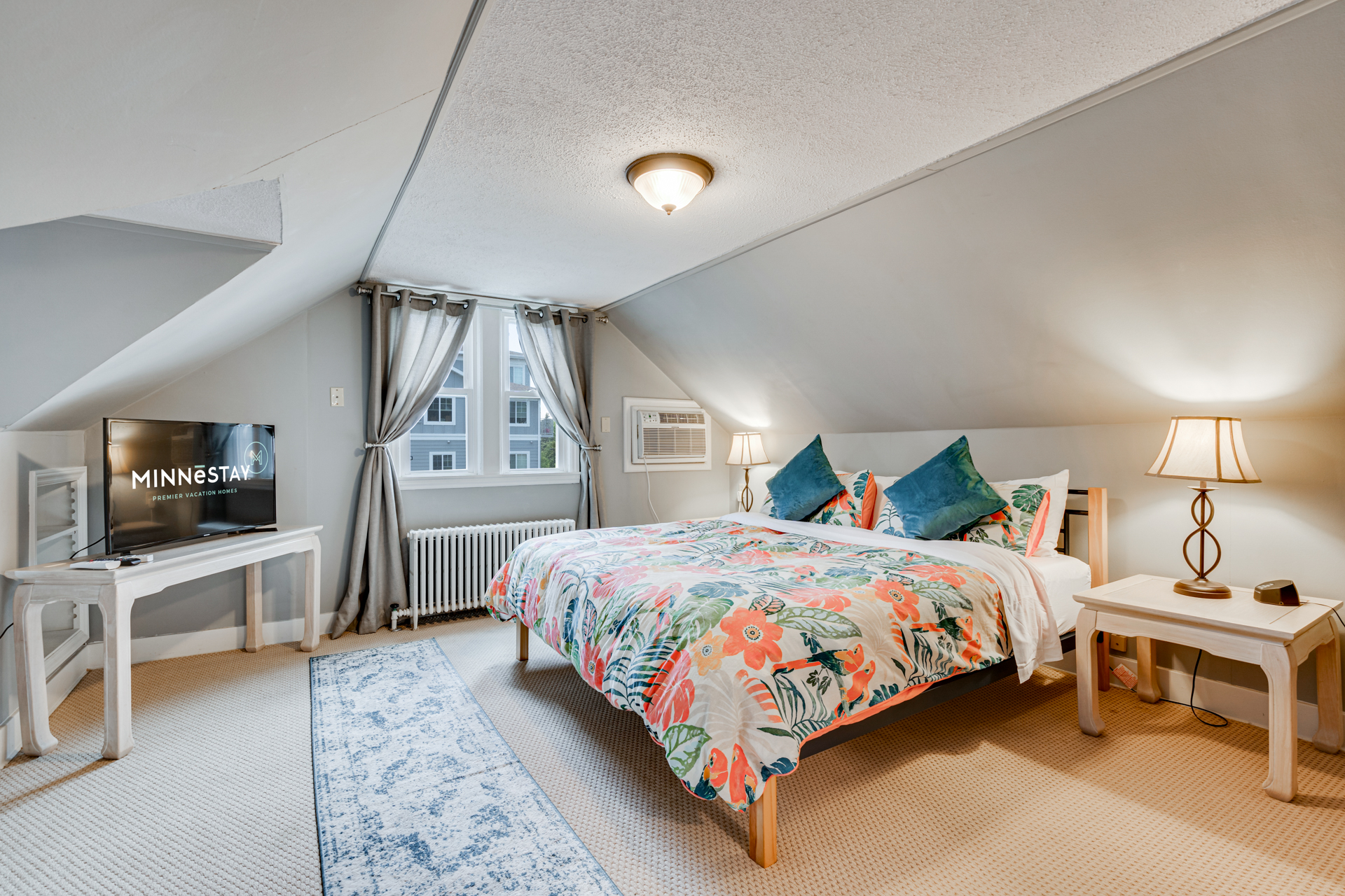 A vibrant attic bedroom with floral decor and cozy furnishings.