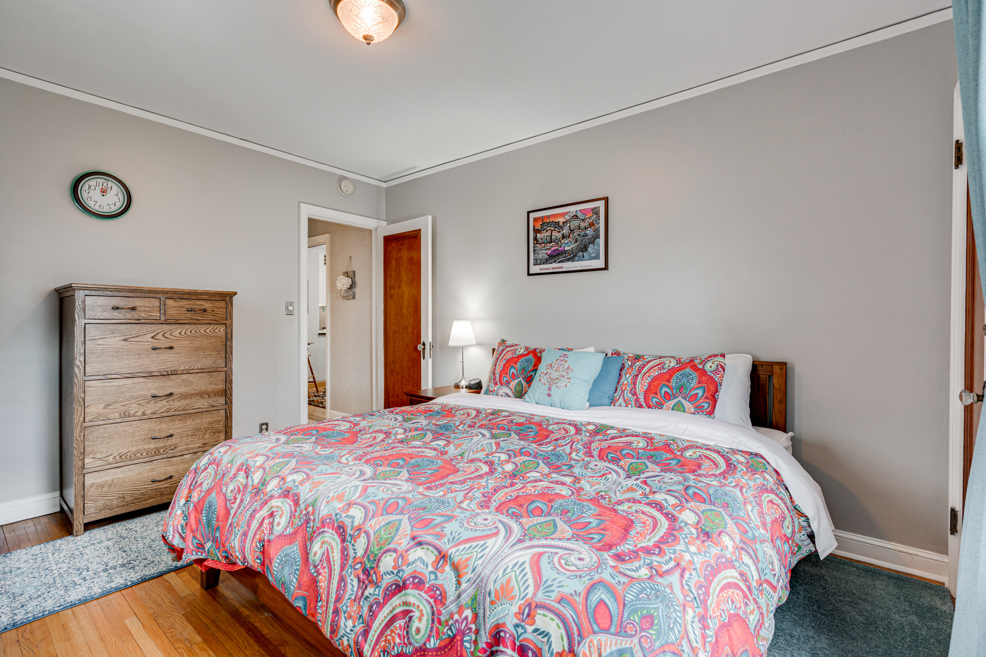 A colorful and cozy bedroom with vibrant bedding and wooden furnishings.