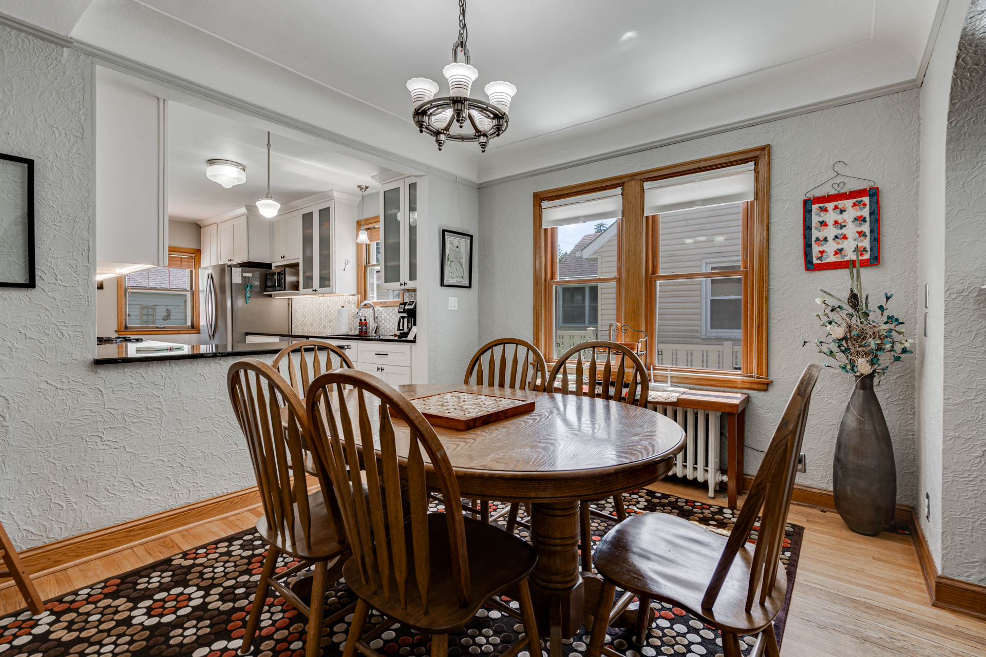 A cozy dining area with wooden furniture and a modern kitchen in the background.