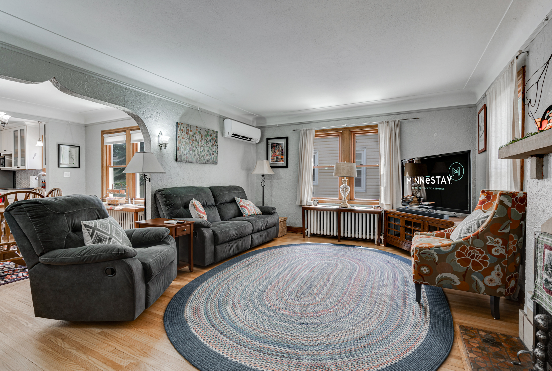 A cozy living room featuring comfortable gray recliners and a braided area rug.