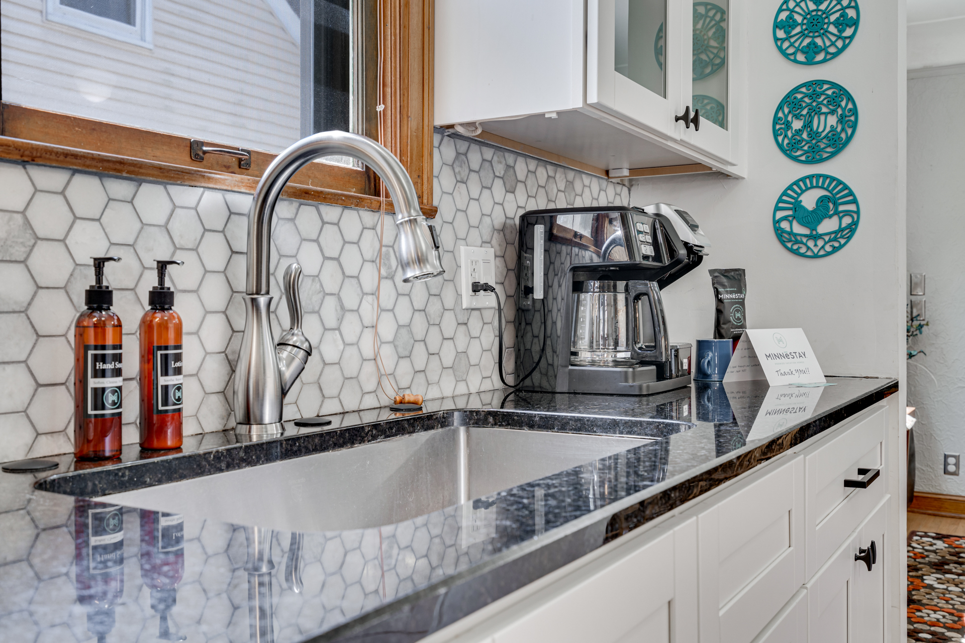 A modern kitchen showcasing a stylish sink and coffee station with decorative elements.