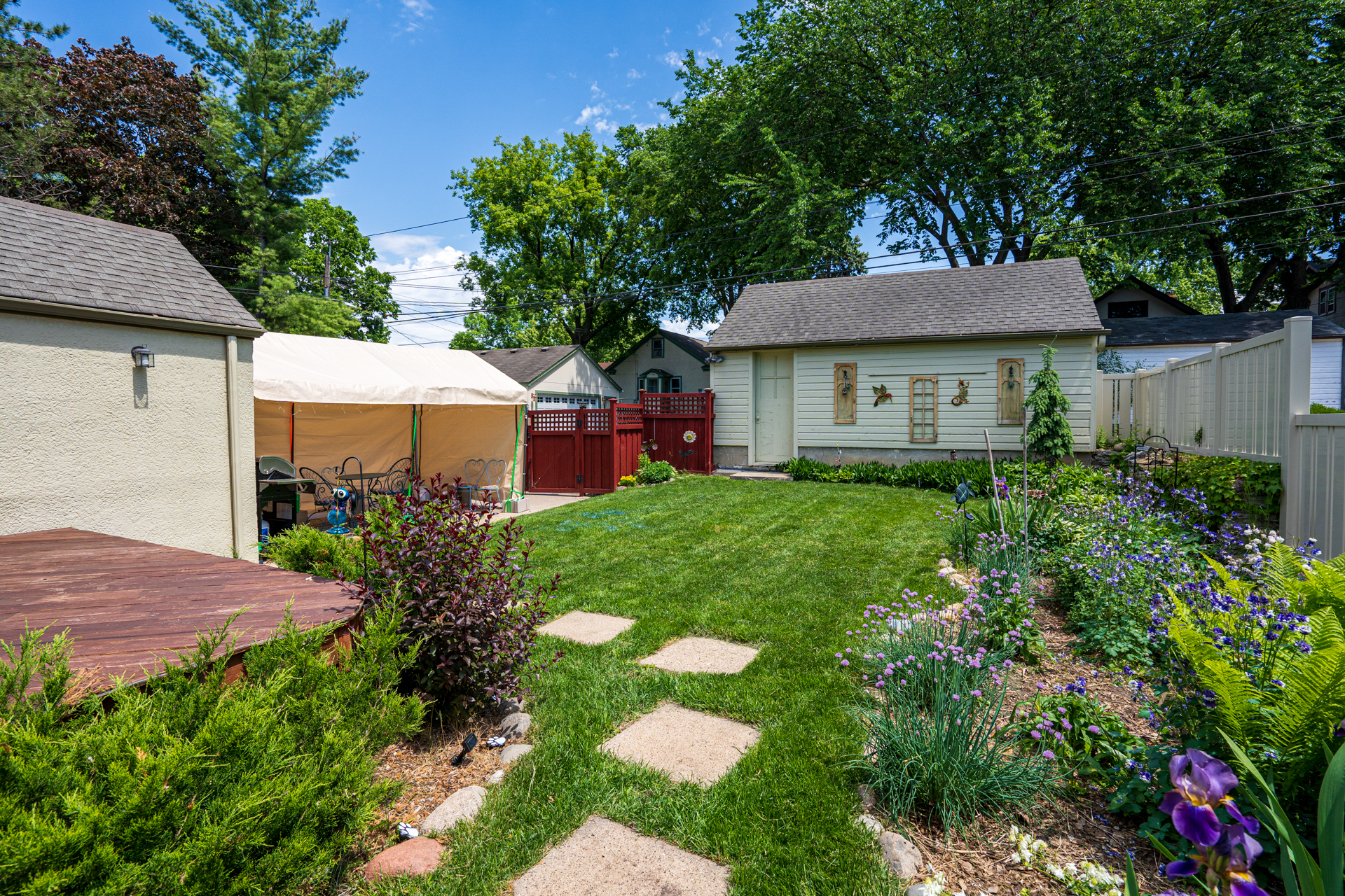 A charming backyard with a vibrant garden and cozy seating.