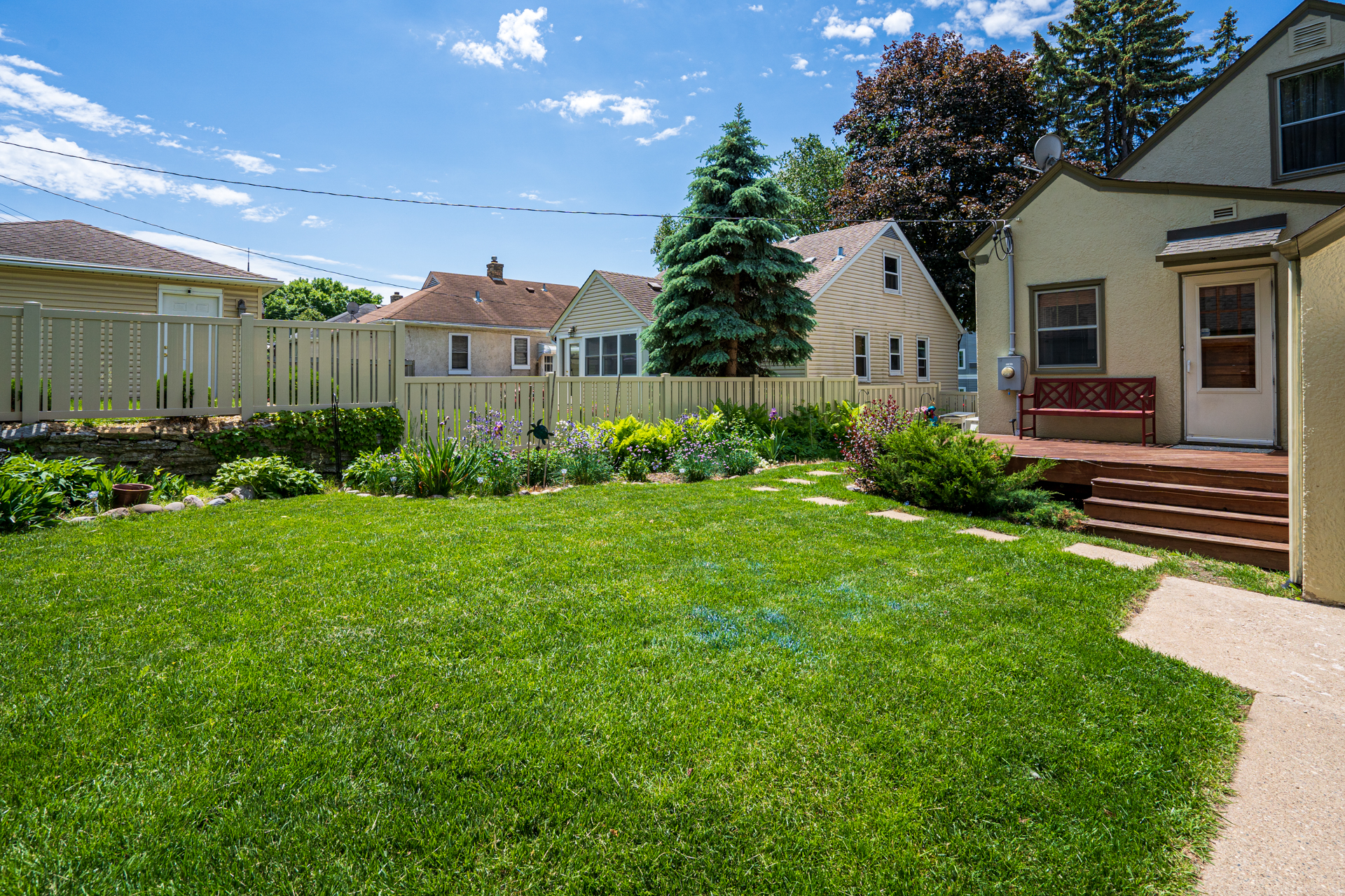 A bright and inviting backyard with lush greenery and a cozy house.