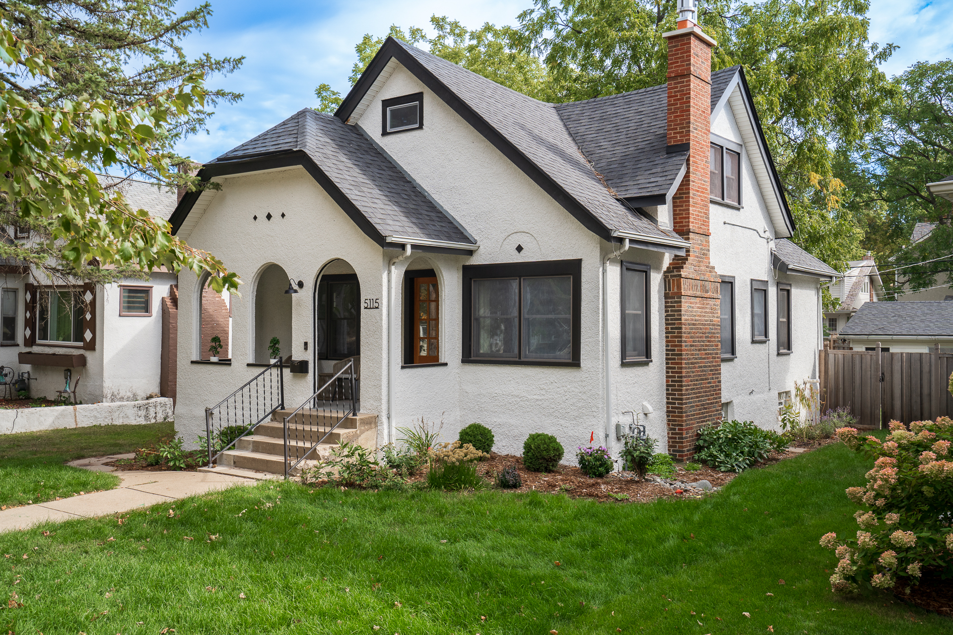 Charming single-family home with lush landscaping and unique architectural features.