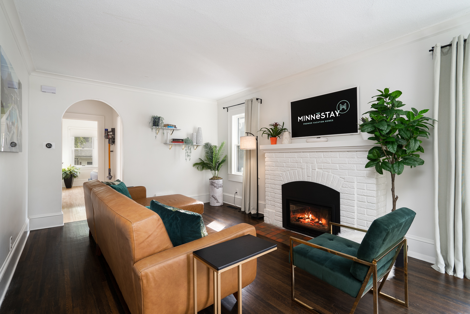 Cozy living room with leather furniture, a fireplace, and modern decor.