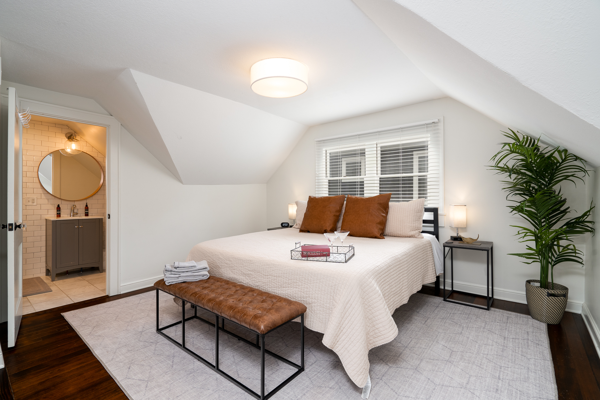 A cozy bedroom with modern decor and an attached bathroom.