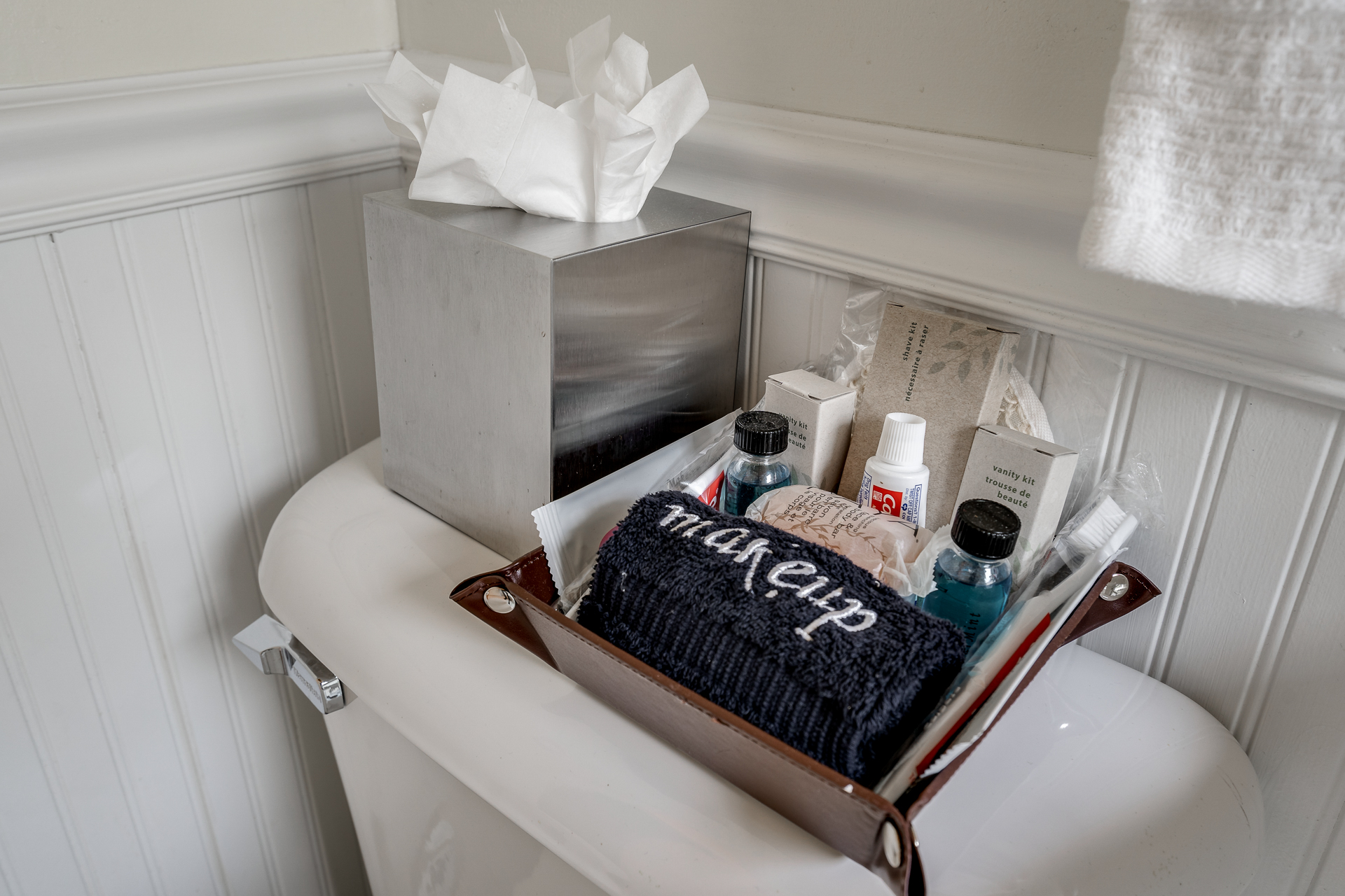 A well-organized bathroom corner with personal care items, including a 'makeup' towel and toiletries.