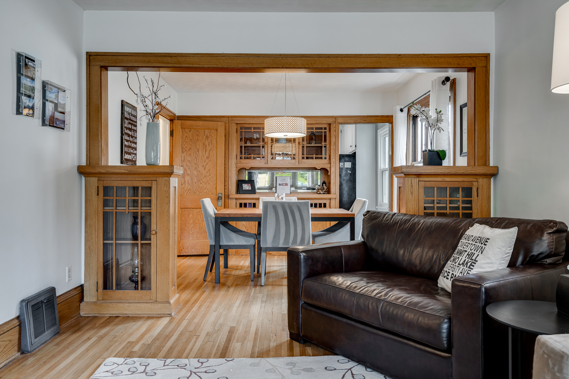 A cozy living space leading to a stylish dining area, featuring modern decor and warm wooden elements.