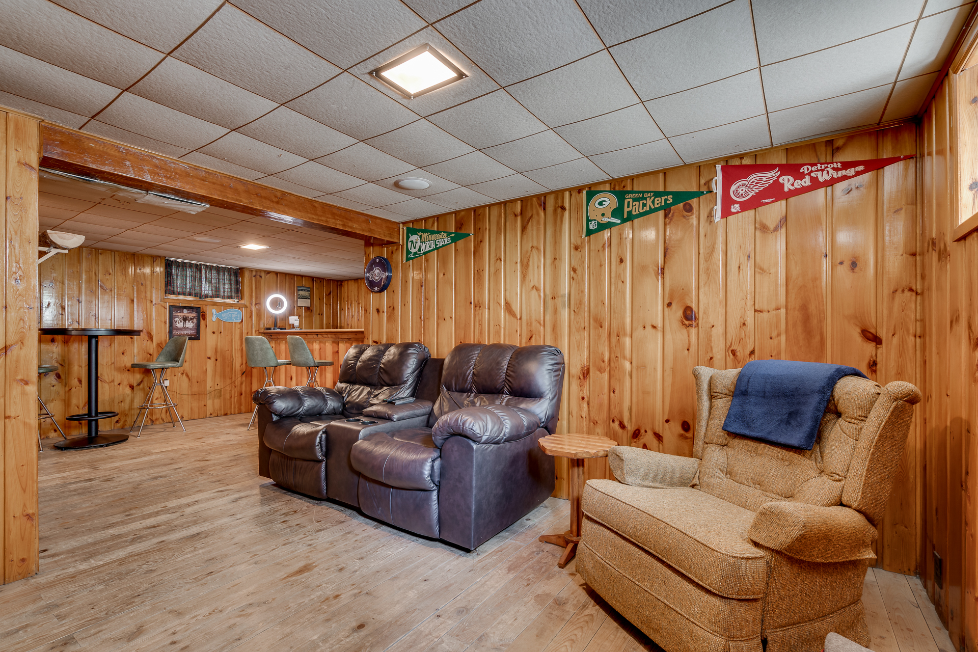 A cozy basement lounge adorned with sports memorabilia and comfortable seating.