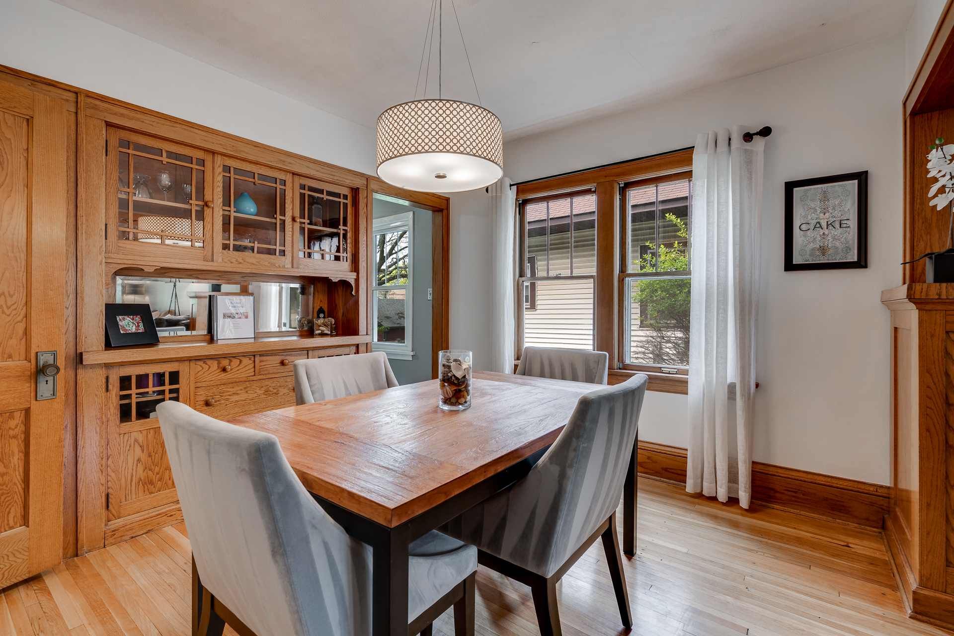 A cozy dining room with a wooden table and elegant gray chairs.