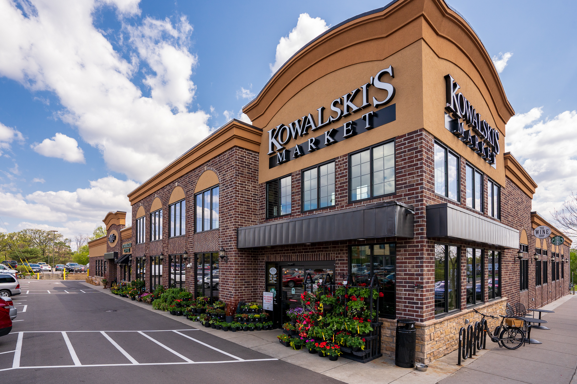 Kowalski's Market exterior showcasing vibrant flowers and welcoming architecture.