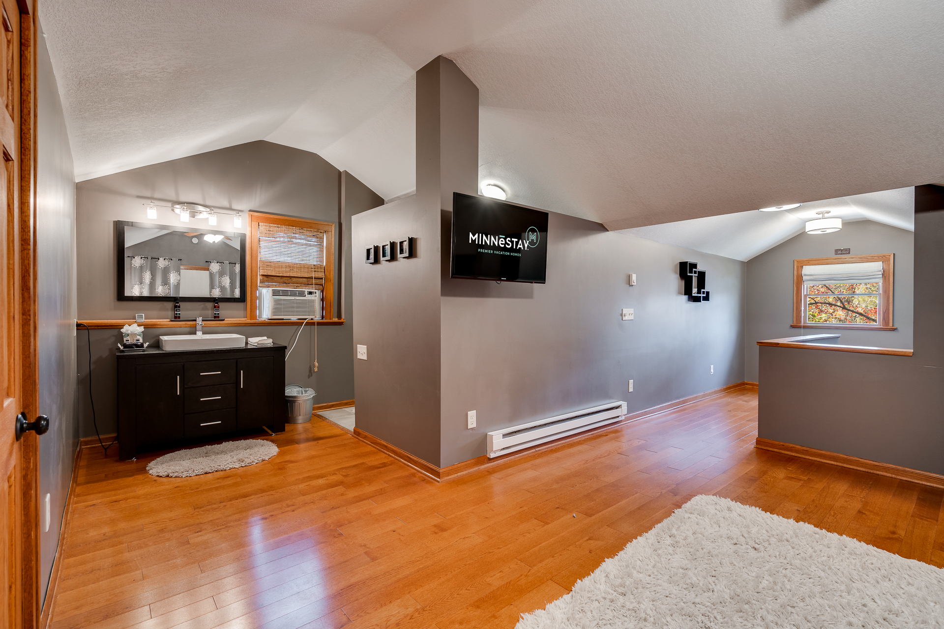 A modern rental space featuring a sleek vanity and cozy decor.