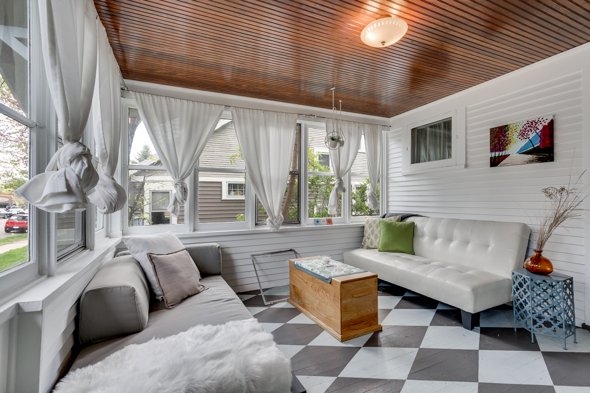 A bright and modern sunroom with stylish furniture and vibrant decor.